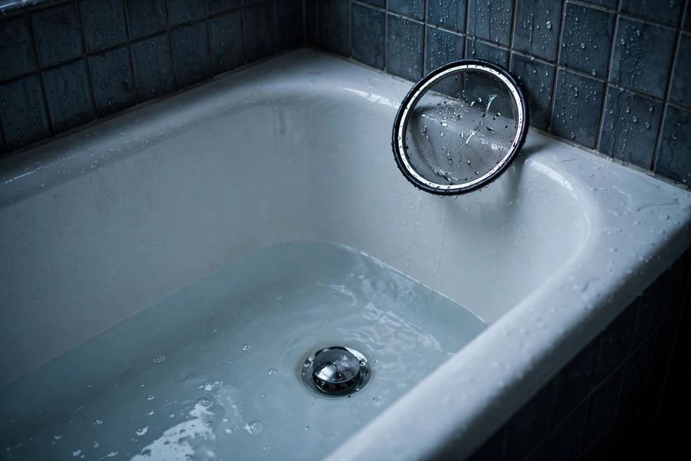 White bathtub with water standing around the drain